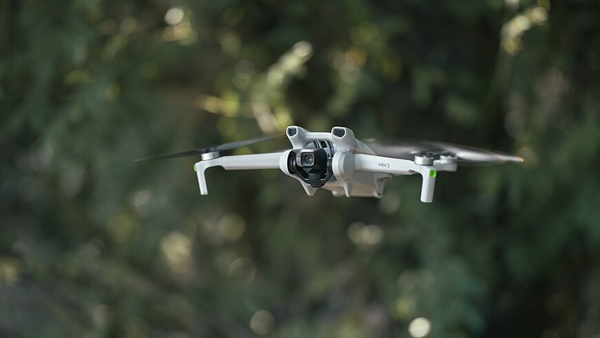 Dron DJI Mini 3 Fly More Combo CP.MA.00000613.01 widok na lecącego drona pod skosem w lewo
