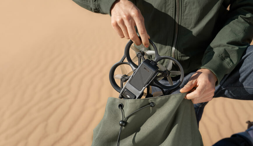 Dron DJI Avata Explorer Combo grafika przedstawia mężczyznę chowającego drona do plecaka