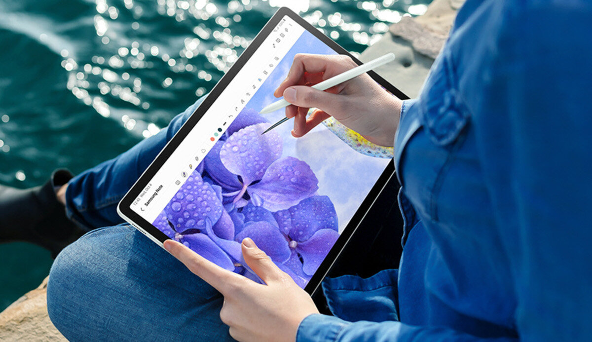 Tablet Samsung Galaxy Tab S9 FE+ grafika przedstawiająca dziewczynę rysującą na tablecie nad wodą
